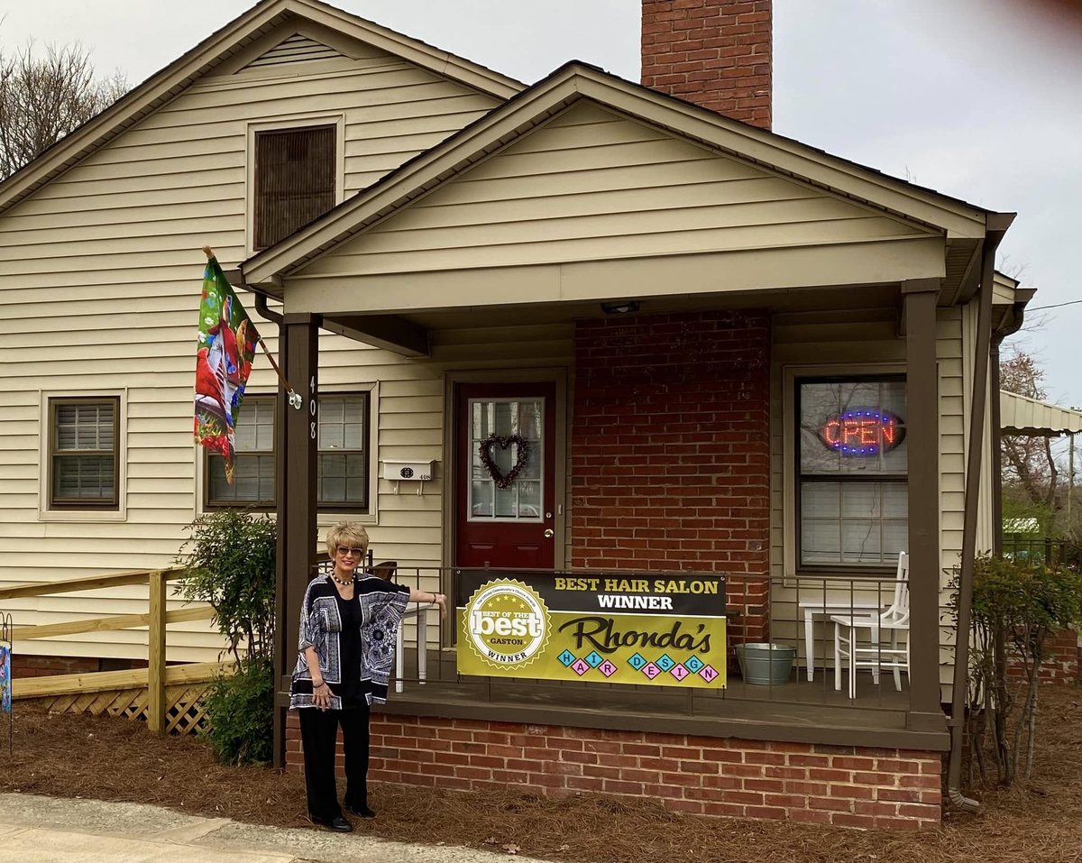 Rhonda Guffey at the Eighth Avenue location with Best Hair Salon Winner banner, Gastonia NC